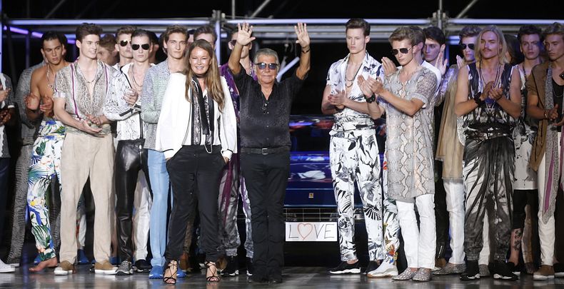 ARCHIVO - El diseñador de modas italiano Roberto Cavalli, centro, recibe el aplauso del público tras el desfile de la colección de caballeros primavera-verano 2015 de Roberto Cavalli en la Semana de la Moda de Milán en Milán, Italia, el 24 de junio de 2014. Cavalli, conocido por su estilo extravagante y glamoroso, murió el viernes 12 de abril de 2024 a los 83 años, anunció su compañía en una publicación de Instagram. (Foto AP/Luca Bruno, archivo)