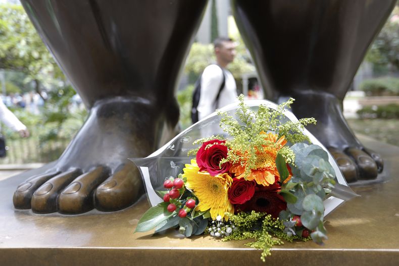 Flores a los pies de una escultura del artista colombiano Fernando Botero en el Parque Botero en Medellín, Colombia, el viernes 15 de septiembre de 2023. El reconocido pintor y escultor colombiano Fernando Botero falleció viernes a los 91 años. (Foto AP/Jaime Saldarriaga)