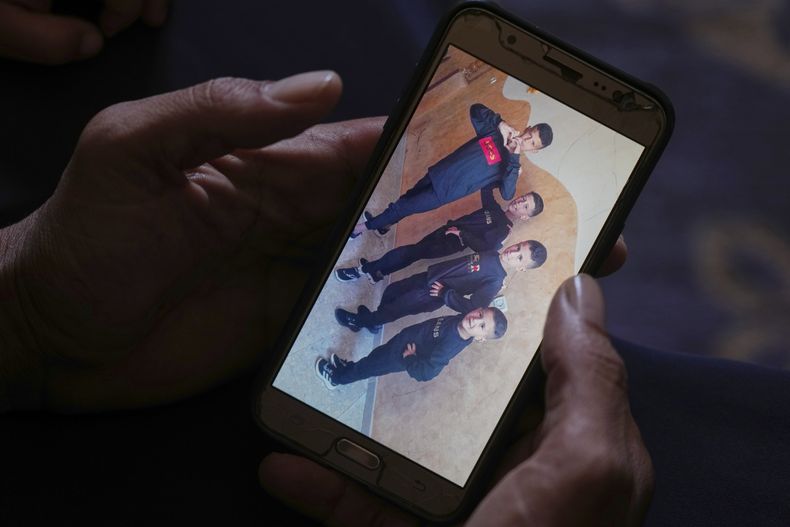 Hatem Al-Nouri muestra una foto en la que aparecen sus hijos Amir (derecha), de 4 años, y Omar (segundo desde la derecha), de 8, acompañados por sus hermanos, mientras habla de cuando Amir y Omar fallecieron a causa de un ataque israelí mientras esperaban recibir suplementos nutricionales en una clínica, durante una entrevista en su casa en Deir al-Balah, Franja de Gaza, el viernes 11 de julio de 2025. (AP Foto/Abdel Kareem Hana)