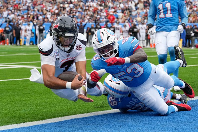 El quarterback de los Texans de Houston, C.J. Stroud (7), se lanza a la zona de anotación para un touchdown tras correr con el balón dejando atrás al safety de los Titans de Tennessee, Tony Adams (29), y a Anthony Hill Jr. (53) durante la segunda mitad de un partido de fútbol americano de la NFL en Nashville, Tennessee, el domingo 11 de octubre de 2026. (Foto AP/George Walker IV)