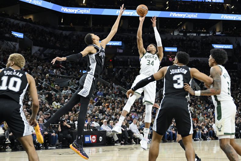 El griego Giannis Antetokounmpo, de los Bucks de Milwaukee, dispara frente al francés Victor Wembanyama, de los Spurs de San Antonio, en el partido del jueves 4 de enero de 2024 (AP Foto/Darren Abate)