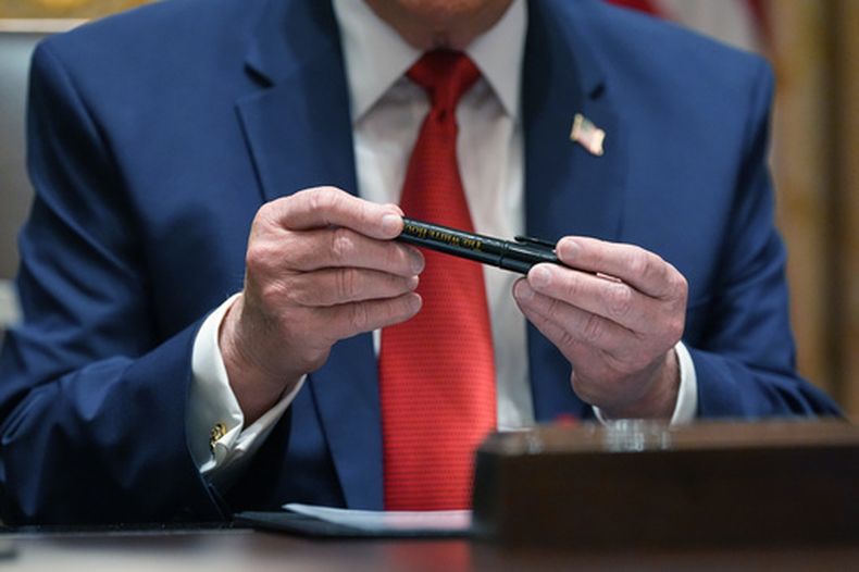 El presidente Donald Trump sostiene un plumón Sharpie que asegura fue producido específicamente para la Casa Blanca, durante una reunión de gabinete, el jueves 26 de marzo de 2026, en Washington. (AP Foto/Alex Brandon)