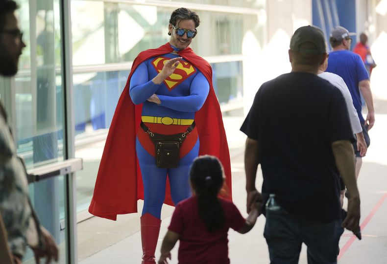 Chris Perry, voluntario de la Comic-Con, de San Diego, saluda a un joven asistente antes de la noche de vista previa internacional de la Comic-Con 2025, el miércoles 23 de julio de 2025, en San Diego. (Foto AP/Chris Pizzello)