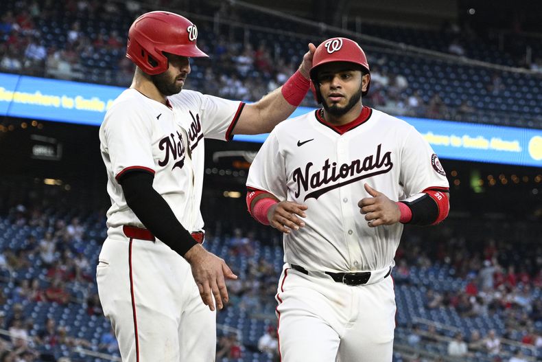 El venezolano de los Nacionales de Washington, Keiber Ruiz (derecha) es felicitado por su compañero de equipo Joey Gallo, luego de anotar en un imparable de Jacob Young durante la quinta entrada del juego de béisbol ante los Mellizos de Minnesota, el lunes 20 de mayo de 2024 en Washington. (AP Foto/Nick Wass)