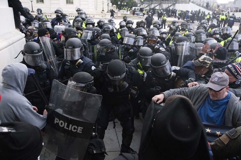 ARCHIVO - En esta fotografía del 6 de enero de 2021, agentes de la policía del Capitolio empujan a alborotadores que intentan entrar al complejo en Washington. (AP Foto/José Luis Magaña, archivo)