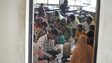 Gente evacuada de un pueblo cerca de Jakhau come en un refugio en Naliya, en el distrito de Kutch, India, el miércoles 14 de junio de 2023. Se esperaba que el ciclón Biparjoy tocara tierra cerca del puerto de Jakhau y fuera la tormenta más fuerte en golpear el oeste de India y Pakistán desde 2021. (AP Foto/Ajit Solanki)