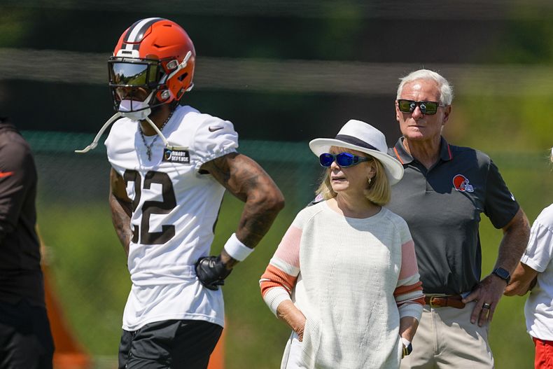 El dueño de los Browns de Cleveland Jimmy Haslam y una amiga de la familia observan la sesión de entrenamiento del equipo en el centro de prácticas el lunes 24 de julio del 2023. (AP Foto/Chris Carlson)