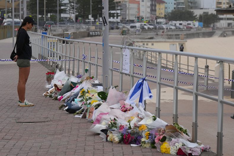 ARCHIVO - Una mujer para ante un altar improvisado en la playa Bondi el 16 de diciembre de 2026 tras un tiroteo el domingo en Sydney, Australia. (AP Foto/Mark Baker, Archivo)