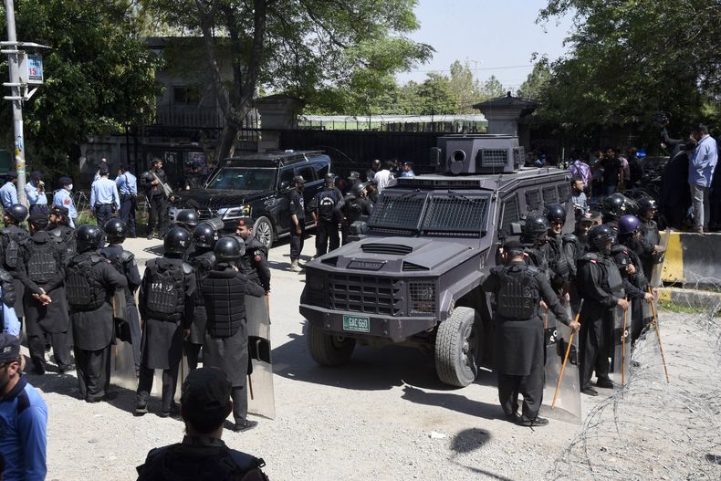 Policías antimotines paquistaníes montan guardia ante un vehículo blindado delante una corte donde comparecía el ex primer ministro de Pakistán, Imran Khan, en Islamabad, Pakistán, el martes 9 de mayo de 2023. Agentes de seguridad paquistaníes detuvieron el martes al ex primer ministro del país Imran Khan, que había comparecido en una corte de la capital, Islamabad, para responder por varios cargos de corrupción, según indicaron la policía y miembros de su partido. (AP Foto/Ghulam Farid)