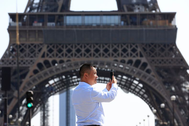 Una persona usa su teléfono cerca de la Torre Eiffel en París, el 31 de agosto de 2022. (Foto AP/Aurelien Morissard, Archivo)