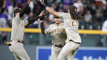 Los dominicanos Juan Soto (izquierda) y Fernando Tatis Jr. (derecha), de los Padres de San Diego, festejan con su compañero Trent Grisham la victoria sobre los Rockies de Colorado, el 9 de junio de 2023 (AP Foto/David Zalubowski)