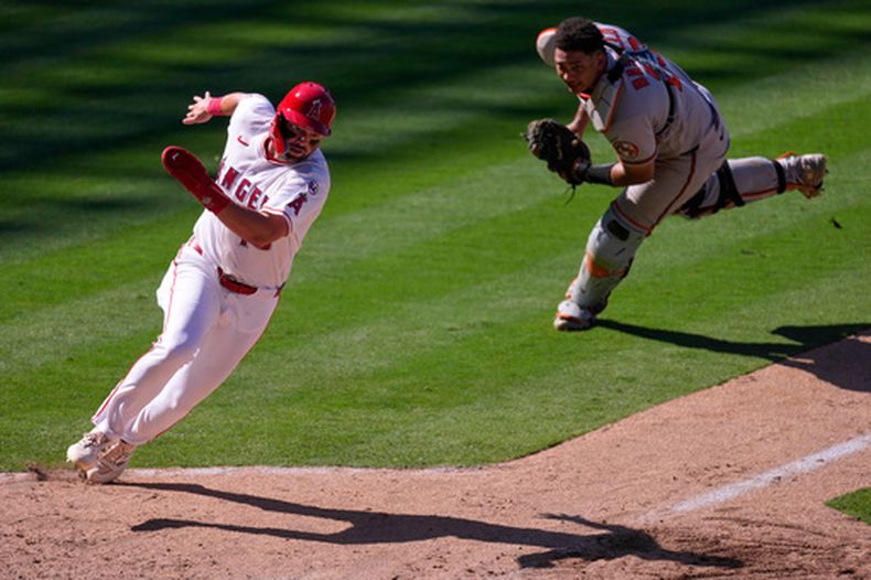 Nolan Schanuel, izquierda, de los Angelinos de Los Ángeles, anota con un sencillo productor de Logan OHoppe con la que dejaron tendidos en el terreno. mientras Samuel Basallo, de los Orioles de Baltimore, no lo pudo sacar durante la 10ma entrada del juego de béisbol de Gramdes Ligas, el miércoles 24 de junio de 2024, en Anaheim, California. (AP Foto/Mark J. Terrill)