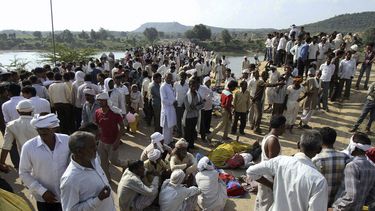 americateve | Varias personas se re&uacute;nen despu&eacute;s de una estampida de personas que dej&oacute; al menos 109 muertos en un puente que cruza el r&iacute;o Sindh en el distrito de Datia, en Madhya Pradesh, el domingo 13 de octubre de 2013. (AP Foto)