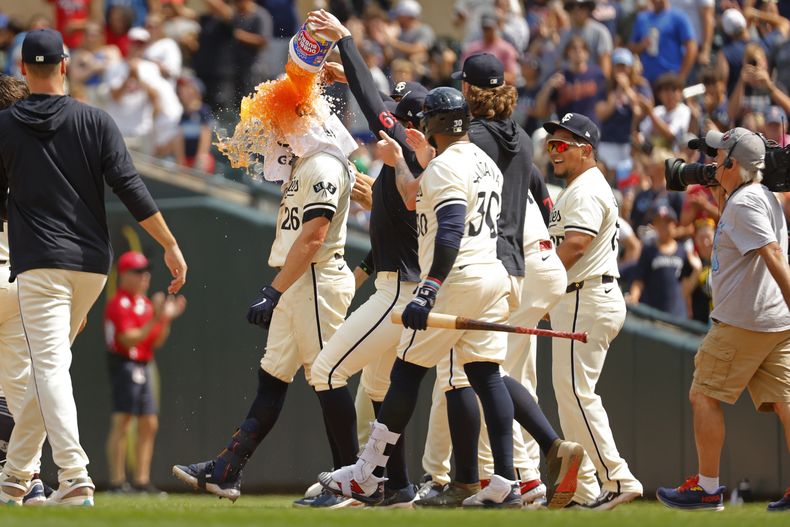 Max Kepler (26), de los Mellizos de Minnesota, recibe un baño de hielo para celebrar su sencillo con el que se definió la victoria sobre los Filis de Filadelfia después del partido de béisbol del miércoles 24 de julio de 2024, en Minneapolis. (AP Foto/Bruce Kluckhohn)