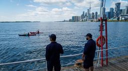 Dos personas miran el lago Ontario y el horizonte de Toronto desde el puerto Toronto en la ciudad del mismo nombre, el martes 25 de agosto de 2026. (Keito Newman/The Canadian Press vía AP)