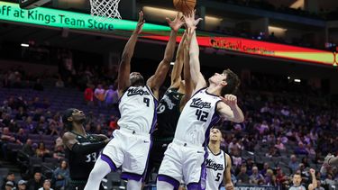 Precious Achiuwa (9) y Maxime Raynaud (42), de los Kings de Sacramento, disputan un rebote frente a Joan Beringer, centro, durante la segunda mitad del juego de baloncesto de la NBA, el domingo 9 de noviembre de 2025. (AP Foto/Sara Nevis)