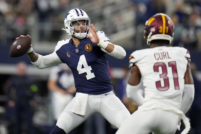 El quarterback de los Cowboys de Dallas Dak Prescott lanza el balón frente al safety de los Commanders de Washington Kamren Curl en el encuentro del jueves 23 de noviembre del 2023. (AP Foto/Julio Cortez)
