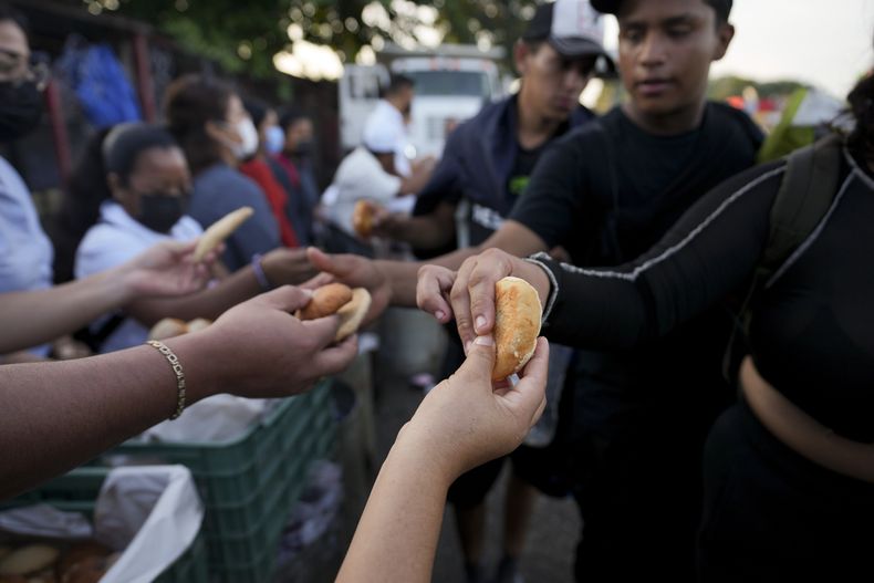 Los migrantes que marchan en caravana por la carretera Huixtla con la esperanza de llegar a la frontera norte de México y luego a Estados Unidos, reciben alimentos de trabajadores en Huehuetán, en el sur de México, el miércoles 6 de noviembre de 2024. (Foto AP/Moisés Castillo)