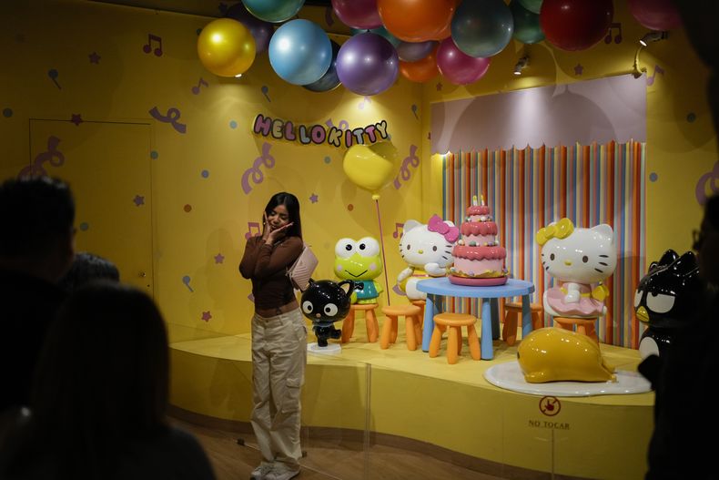 Una fan del personaje japonés Hello Kitty posa para fotografías en un café con temática de Hello Kitty en la Ciudad de México, el jueves 10 de octubre de 2024. (Foto AP/Eduardo Verdugo)