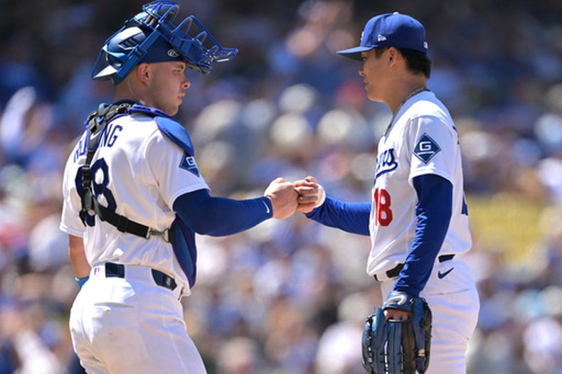 El receptor de los Dodgers, Dalton Rushing, izquierda, felicita al abridor del equipo, Yoshinobu Yamamoto, derecha, al ser retirado del montículo en la sexta entrada del juego de béisbol de Grandes Ligas contra los Filis de Filadelfia, el domingo 31 de mayo de 2026, en Los Ángeles. (AP Foto/Jayne Kamin-Oncea)