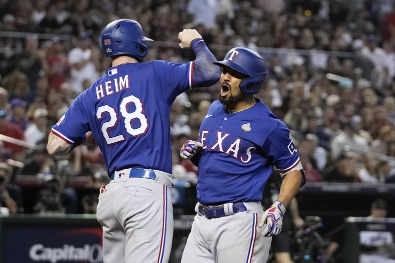 Marcus Semien, de los Rangers de Texas, festeja su jonrón de dos carreras con Jonah Heim, en el quinto juego de la Serie Mundial ante los Diamondbacks de Arizona, el miércoles 1 de noviembre de 2023 (AP Foto/Brynn Anderson)