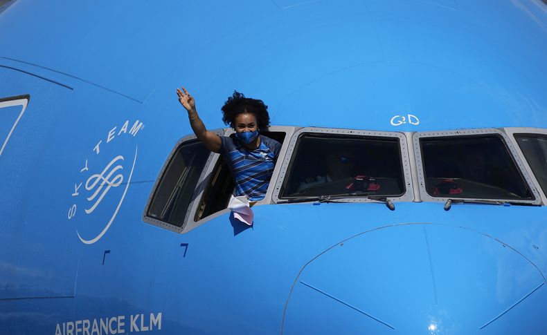 ARCHIVO - La pesista ecuatoriana Neisi Dajomes saluda desde la cabina de un avión al volver a su país el 4 de agosto de 2021, luego de ganar el oro en los Juegos Olímpicos de Tokio (AP Foto/Dolores Ochoa, archivo)