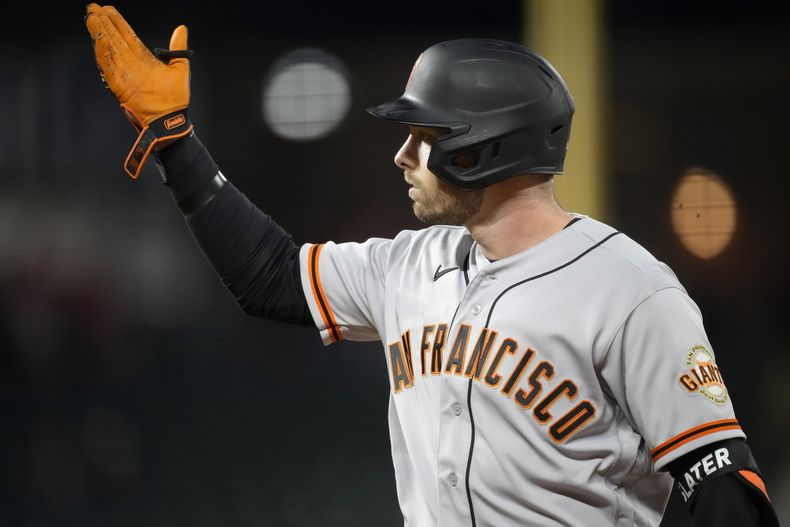 Austin Slater, de los Gigantes de San Francisco, hace un gesto hacia la cueva, tras remolcar una carrera con un sencillo en el duelo del miércoles 7 de junio de 2023, ante los Rockies de Colorado (AP Foto/David Zalubowski)