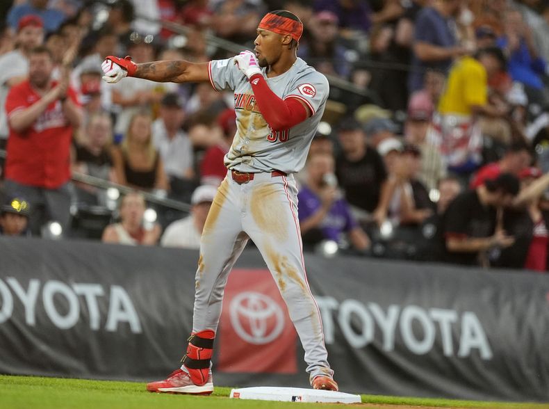 Will Benson, de los Rojos de Cincinnati, celebra después de llegar a salvo a tercera base con un triple que produjo dos carreras contra el abridor de los Rockies de Colorado, Ryan Feltner, en la cuarta entrada del juego de béisbol el lunes 3 de junio de 2024, en Denver. (AP Foto/David Zalubowski)