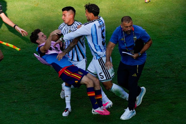 El centrocampista español Gavi cae el piso en medio de una pelea con los argentinos Leandro Paredes (5) y Thiago Almada durante la final de la Copa del Mundo entre España y Argentina, el domingo 19 de julio de 2026, en East Rutherford, Nueva Jersey. (AP Foto/Yuki Iwamura)