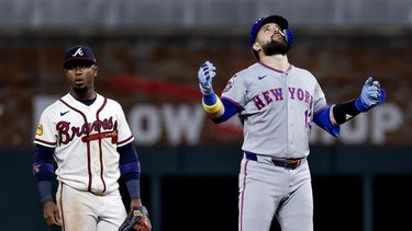 Luis Torrens, derecha, de los Mets de Nueva York, reacciona después de batear un doble productor de dos carreras mientras el segunda base de los Bravos de Atlanta, Ozzie Albies, izquierda, observa durante la décima entrada del juego de béisbol de Grandes Ligas del lunes 6 de julio de 2026, en Atlanta. (AP Foto/Erik S. Lesser)
