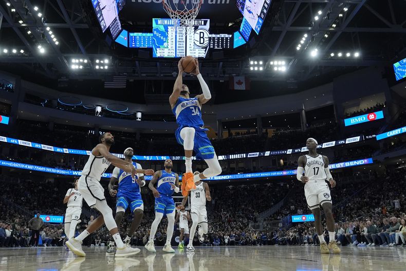 Giannis Antetokounmpo de los Bucks de Milwaukee salta con el balón para anotar en el encuentro ante los Nets de Brooklyn el jueves 21 de marzo del 2024. (AP Foto/Morry Gash)