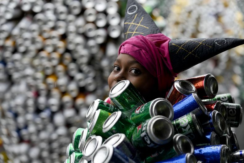 Una integrante del Bloco da Latinha, con el característico traje hecho a base de latas de cerveza y refrescos, participa en el desfile de carnaval el domingo 11 de febrero de 2024, en Madre de Deus, Brasil. (AP Foto/Eraldo Peres)