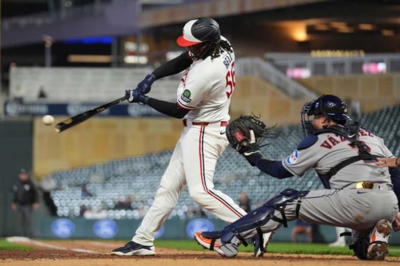 Josh Bell, izquierda, de los Mellizos de Minnesota, conecta un sencillo producgtor durante la sexta entrada del juego de béisbol de Grandes Ligas contra los Astros de Houston, el lunes 18 de mayo de 2026, en Minneapolis. (AP Foto/Abbie Parr)