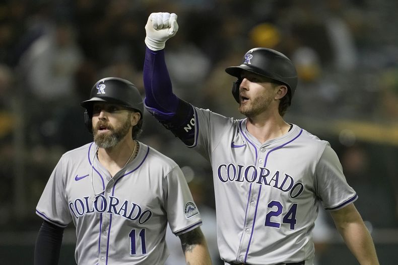 Ryan McMahon (24), de los Rockies de Colorado, festeja un jonrón que remolcó a Jake Cave (11) durante el juego ante los Atléticos de Oakland, el miércoles 22 de mayo de 2024 (AP Foto/Jeff Chiu)
