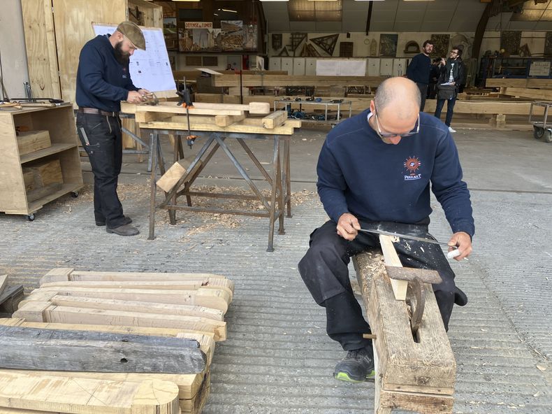 Carpinteros trabajan en piezas que formarán parte de la estructura del nuevo tejado de la catedral de Notre Dame de París, el 25 de mayo de 2023, cerca de Angers, en el oeste de Francia. Los carpinteros que construyen el nuevo armazón para el tejado de la iglesia, arrasado por un incendio, emplean las mismas herramientas y técnicas que sus predecesores medievales. Para ellos, trabajar con hachas y vigas de roble ha sido una especie de viaje en el tiempo. (AP Foto/Jeffrey Schaeffer)
