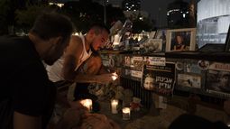 Gente encendiendo velas en un altar de recuerdo a las víctimas del ataque transfronterizo de Hamás del 7 de octubre contra Israel, la víspera del primer aniversario del ataque en Tel Aviv, Israel, el domingo 6 de octubre de 2024. (AP Foto/Oded Balilty)