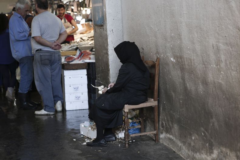 Una mujer vende ajo en un mercado de pescado en Atenas el 16 de octubre del 2014. Grecia vuelve a estar en el foco de las tribulaciones financieras europeas y la comisi&oacute;n ejecutiva de la Uni&oacute;n Europea prometi&oacute; continuar su apoyo finan