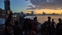 Gente observa el atardecer desde el Malecón durante un apagón en La Habana, el lunes 6 de marzo de 2026. (AP Foto/Ramón Espinosa)
