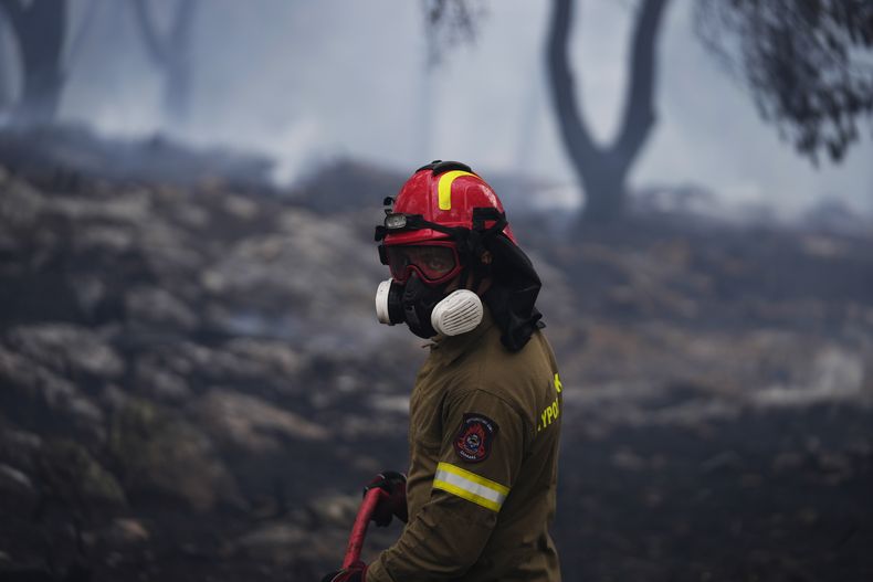 Un bombero rocía agua dentro de un bosque en el suburbio de Stamata, en el norte de Atenas, Grecia, el lunes 4 de septiembre de 2023. (Foto AP/Thanassis Stavrakis)