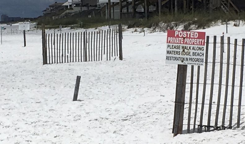 ARCHIVO- Un cartel en el borde de una playa pública que marca dónde comienzan las playas privadas en Santa Rosa Beach, Florida, el 15 de mayo de 2018. (Foto AP/Brendan Farrington, archivo)