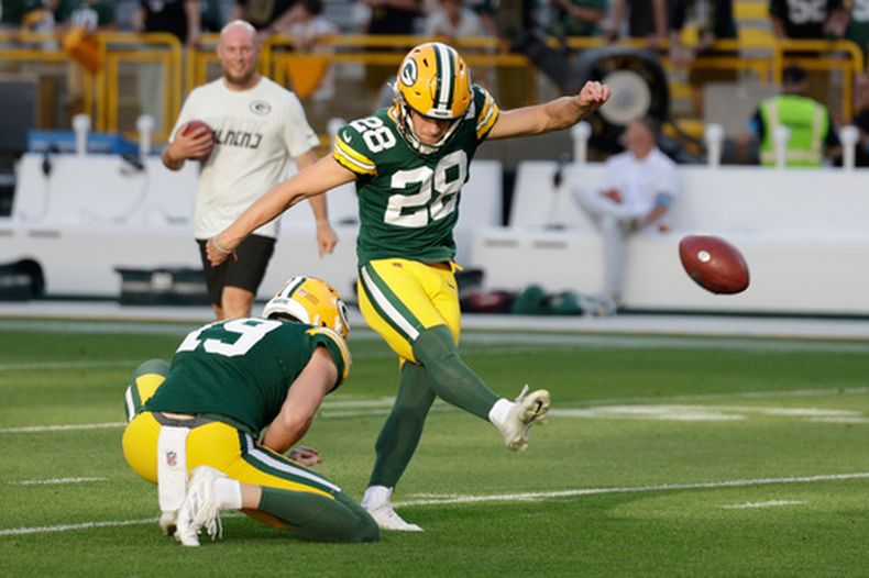 El pateador de los Packers de Green Bay Trey Smack patea el balón que sostiene Daniel Whelan durante el encuentro de pretemporada ante los Cardinals de Arizona el viernes 28 de agosto del 2026. (AP Foto/Matt Ludtke)