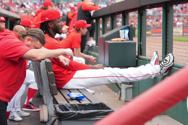 El campocorto de los Rojos de Cincinnati, Elly de la Cruz (al frente a la derecha), se sienta en la banca tras ser retirado de la alineación debido a una lesión durante la tercera entrada de un partido de béisbol contra los Reales de Kansas City, el lunes 1 de junio de 2026, en Cincinnati. (Foto AP/Kareem Elgazzar)