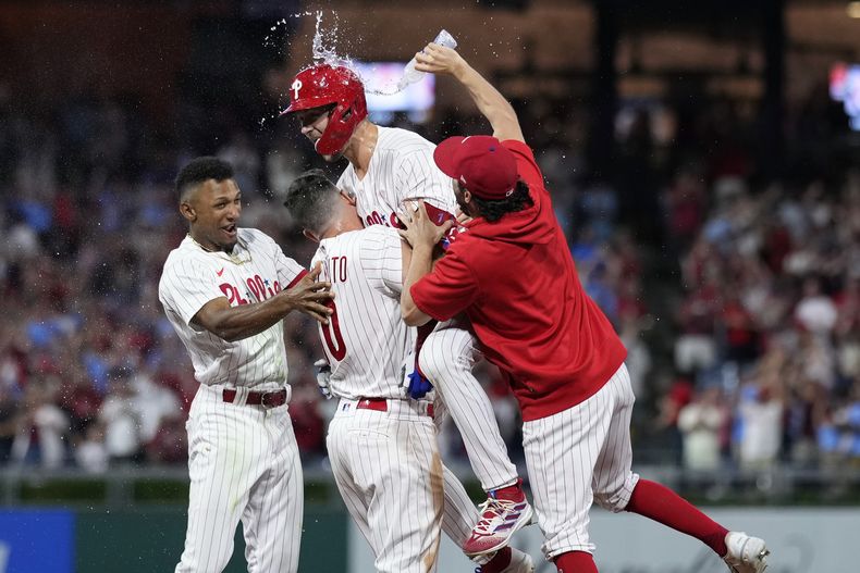 Trea Turner, de los Filis de Filadelfia, festeja con sus compañeros luego de batear el sencillo del triunfo ante los Gigantes de San Francisco, el martes 22 de agosto de 2023 (AP Foto/Matt Slocum)