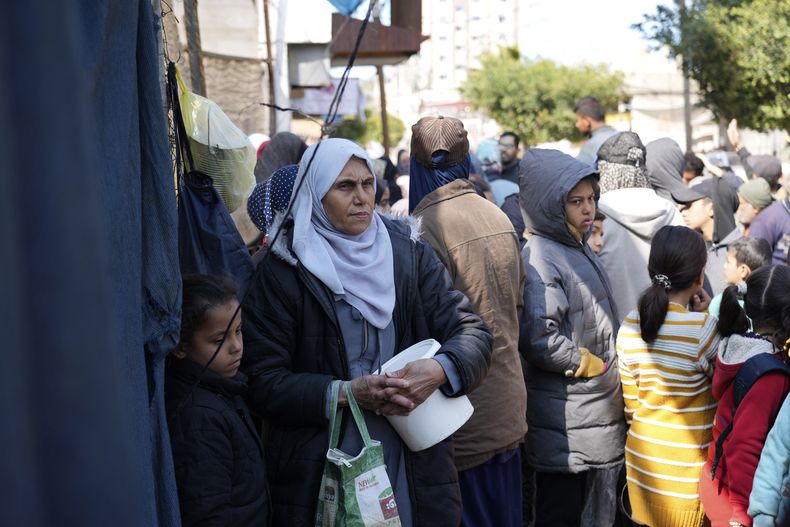 Palestinos hacen fila para recibir alimentos, en Deir al-Balah, en la Franja de Gaza, el 14 de febrero de 2025. (AP Foto/Abdel Kareem Hana)