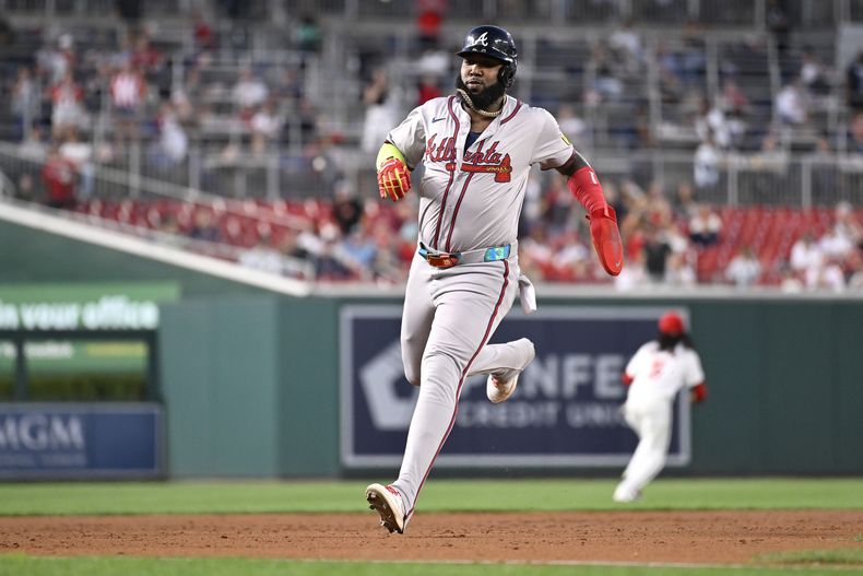 Marcell Ozuna de los Bravos de Atlanta avanza a tercera base tras un doble de Matt Olson ante los Nacionales de Washington, el martes 10 de septiembre de 2024, en Washington. (AP Foto/John McDonnell)