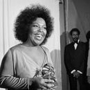 ARCHIVO - Roberta Flack sonríe mientras sostiene el premio Grammy que recibió por su álbum Killing Me Softly With His Song ante la mirada del cantante Isaac Hayes, derecha, en la entrega de los premios Grammy en Los Ángeles, el 4 de marzo de 1974. (AP Foto/Harold Filan, archivo)