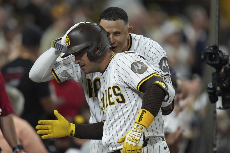 José Iglesias, izquierda, de los Padres de San Diego, celebra con su compañero Manny Machado después de batear un cuadrangular durante la quinta entrada del juego de béisbol de Grandes Ligas contra los Cerveceros de Milwaukee, el lunes 22 de septiembre de 2025, en San Diego. (AP Foto/Gregory Bull)