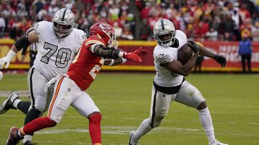 El corredor de los Raiders de Las Vegas Zamir White corre con el balón mientras lo persigue el safety de los Chiefs de Kansas City Mike Edwards y el guard de los Raiders Greg Van Roten observa el lunes 25 de diciembre del 2023. (AP Foto/Ed Zurga)
