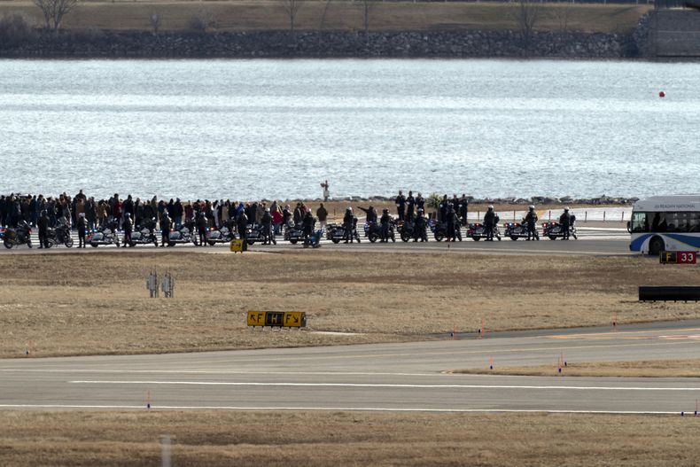 Los familiares de las víctimas de una colisión en el aire entre un avión de American Airlines y un helicóptero del Ejército caminan hasta el final de la pista 33 cerca del lugar de los restos en el río Potomac en el Aeropuerto Nacional Ronald Reagan de Washington, el domingo 2 de febrero de 2025, en Arlington, Virginia (AP Foto/José Luis Magaña)