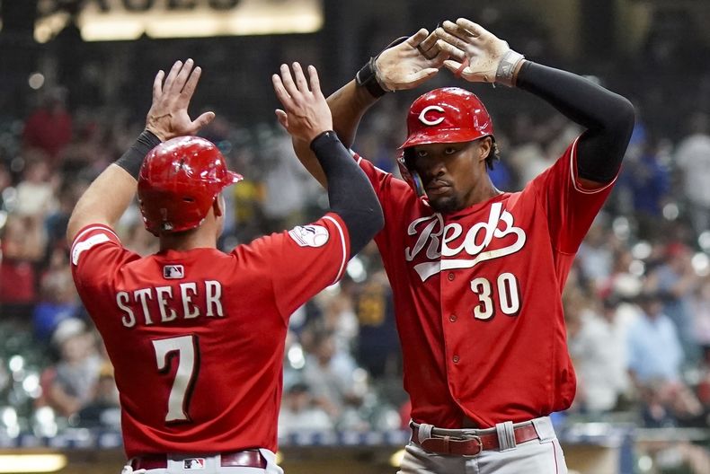 Will Benson de los Rojos de Cincinnati es felicitado por su compañero Spencer Steer Cincinnati Reds luego de conectar un cuadrangular de dos carreras en el noveno episodio del juego contra los Cerveceros de Milwaukee, en Milwaukee. Martes 25 de julio de 2023. (AP Foto/Morry Gash)